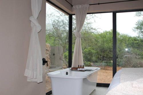 uma banheira branca num quarto com uma janela em Lereko Bush Villa em Marloth Park