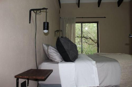um quarto com uma cama com almofadas e uma janela em Lereko Bush Villa em Marloth Park