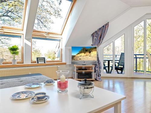 een woonkamer met grote ramen en een tafel bij Haus Seeblick Maritim in Am Schwarzen Busch