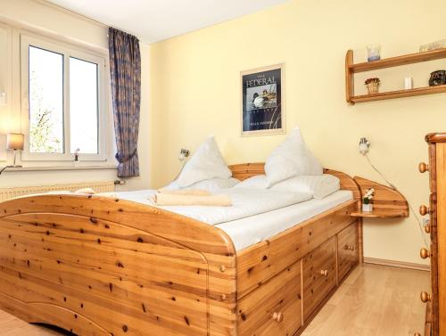 a large wooden bed in a room with a window at Haus Seeblick Maritim in Am Schwarzen Busch