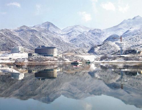 un cuerpo de agua con montañas en el fondo en Cheongpung Resort en Jecheon