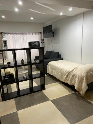ein Wohnzimmer mit einem Bett und einem Sofa in der Unterkunft Depto Monte Grande a 15 minutos del Aeropuerto 1 con estacionamiento Desayuno gratuito y calefacción in Monte Grande