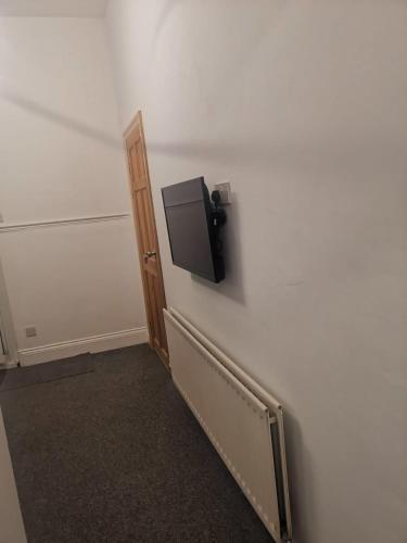 a room with a tv on a wall at The Vacationers - Pvt Rooms with Shared Bath in Sunderland