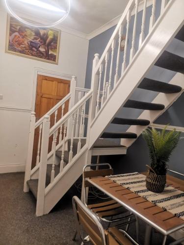 a staircase in a room with a table and chairs at The Vacationers - Pvt Rooms with Shared Bath in Sunderland
