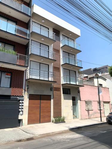 een appartementencomplex met een houten deur in een straat bij Kolben Nuoma in Mexico-Stad