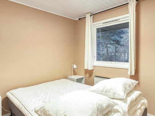En eller flere senge i et værelse på Holiday home Rødby LV
