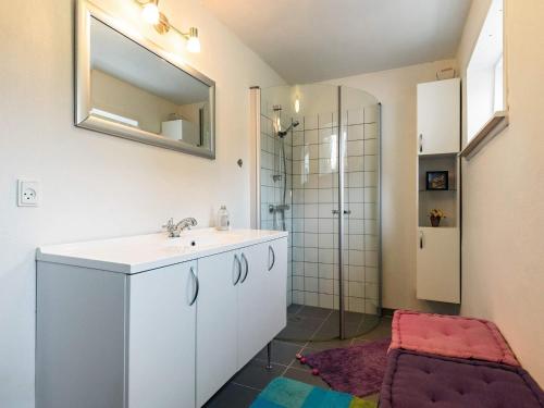 y baño con lavabo, espejo y ducha. en Holiday home Læsø LIII, en Læsø