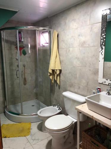 y baño con ducha, aseo y lavamanos. en El Rejunte en Miramar