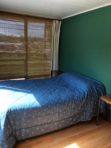 1 dormitorio con cama y pared verde en El Rejunte en Miramar