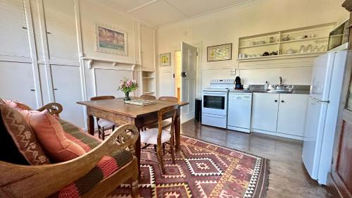 a living room with a table and a kitchen at The Whitestone in Oamaru