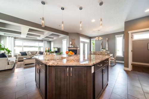 una cocina con una gran isla en la sala de estar en Amazing Luxe Home, AC, HUGE Yard, FirePit, Pet Friendly, Sleeps 10!, en Edmonton