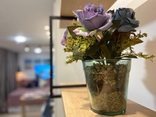 a vase filled with flowers sitting on a table at Recanto Novo Premium Flat in Cabo Frio