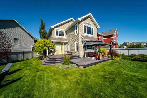 une maison avec une cour avec de l'herbe verte dans l'établissement Amazing Luxe Home, AC, HUGE Yard, FirePit, Pet Friendly, Sleeps 10!, à Edmonton