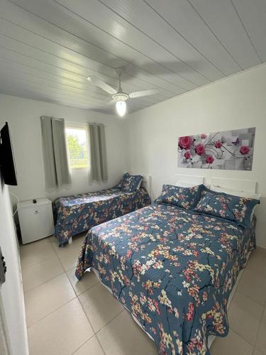 a bedroom with two beds and a ceiling fan at POUSADA RECANTO SÃO JORGE in Águas de Lindóia