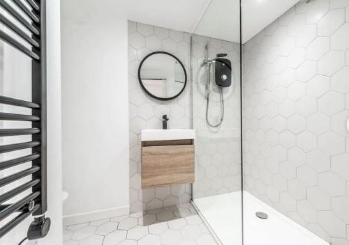 a bathroom with a shower with a sink and a mirror at 1 bedroom modern duplex in Southampton