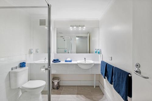 a white bathroom with a toilet and a sink at The River Boat Hotel - Echuca in Echuca