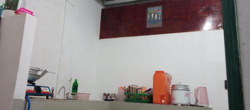 a kitchen counter with a shelf with utensils at The Plant House in Iloilo City 12Pax in Iloilo City