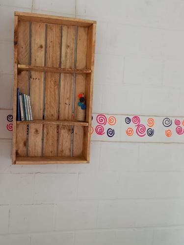 una mensola in legno su un muro con libri di Hostal La Casa Rosada a Lejanías