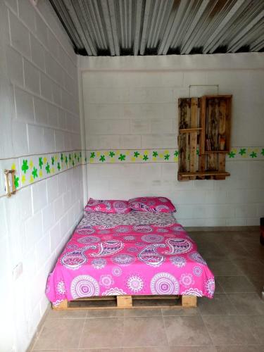 una camera con letto rosa di Hostal La Casa Rosada a Lejanías