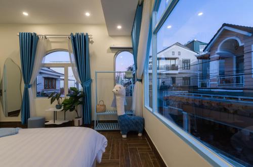 a bedroom with a bed and a large window at Moc Thach Blue House DaLat in Da Lat