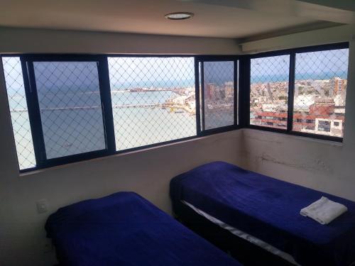 Habitación con 2 camas en una habitación con ventanas en Flat na Beira Mar Mucuripe, en Fortaleza