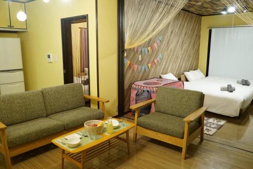 une chambre d'hôtel avec un lit, deux chaises et une table dans l'établissement Cachette -SEVEN Hotels and Resorts-, à Uruma