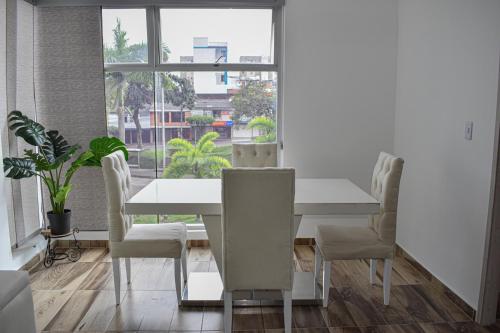 una sala da pranzo bianca con tavolo e sedie bianchi di Acogedor Apartamento, excelente ubicación. Pereira a Pereira