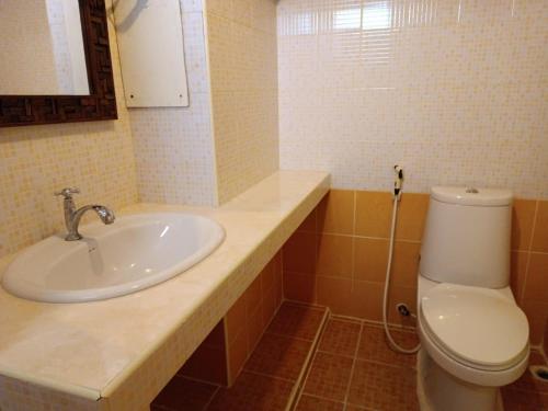 OYO 75417 Grandview Condominia في بانكوك: حمام مع حوض ومرحاض
