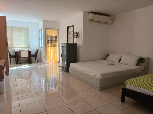 曼谷的住宿－OYO 75417 Grandview Condominia，一间卧室配有一张床、一间厨房和一张桌子