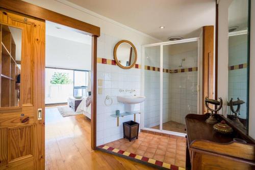 a bathroom with a sink and a shower with a mirror at West End Warehousebathers Beachrooftop Balcony in Fremantle