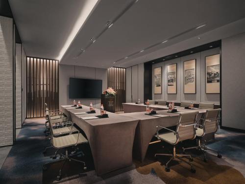 a conference room with a long table and chairs at HUALUXE Kunshan Huaqiao by IHG - F1 Racing Preferred Hotel in Kunshan