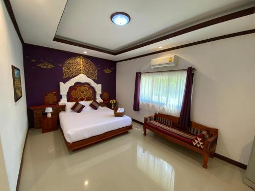 a bedroom with a bed and a bench in it at Phiphu Art and Gallery Boutique Sukhothai in Sukhothai