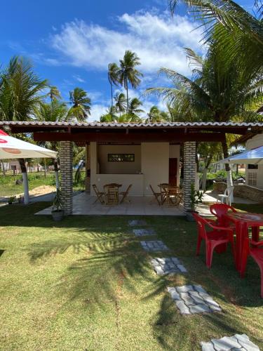 eine Terrasse mit Tischen und Stühlen im Hof in der Unterkunft Pousada Do Vozinho in Touros