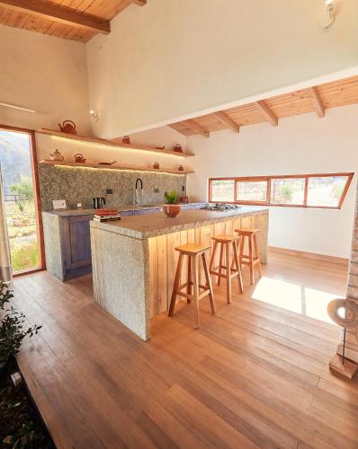 an open kitchen with a large island and wooden floors at Wayarumi Skyhotel in Carhuaz