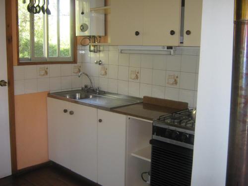 a small kitchen with a sink and a stove at Hostería y Spa Llano Real in Olmué
