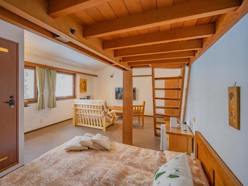 a bedroom with a bed and a room with a ladder at Lodge Scole in Zaō Onsen