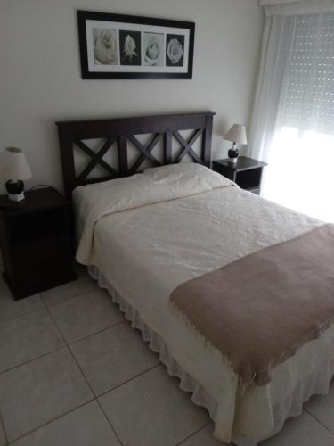 1 dormitorio con 1 cama grande y 2 mesitas de noche en Aptos en 12 Lunas, en Punta del Este