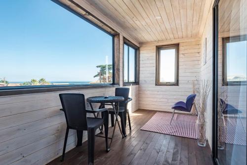 a room with chairs and a table and windows at Pichilemu Apart Hotel in Pichilemu