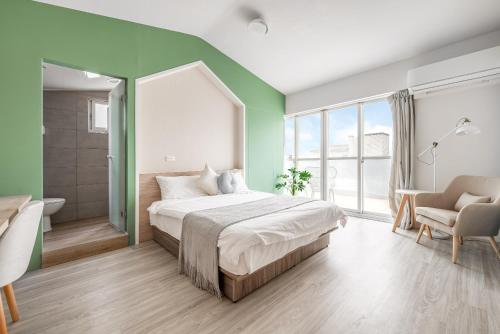 Un dormitorio con una cama grande y una pared verde en 澎湖芸庭旅店 l 全自助入住, en Magong