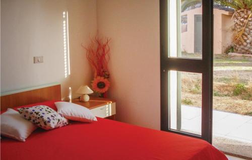 een slaapkamer met een rood bed en een raam bij Nice Apartment In Valledoria With Outdoor Swimming Pool And 1 Bedrooms in Valledoria