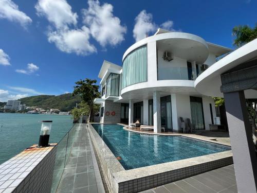 ein Haus mit einem Pool neben dem Wasser in der Unterkunft Nancy Grand Strip Villa Imperial 1 in Vũng Tàu