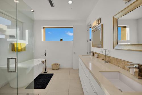 y baño con 2 lavabos, bañera y espejo. en Breathtaking Luxury Villa Architectural Jewel en Palm Springs