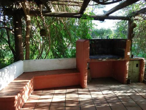 un banco en un porche con árboles al fondo en Cabaña del bosque 5 personas equipada totalmente, en La Paloma