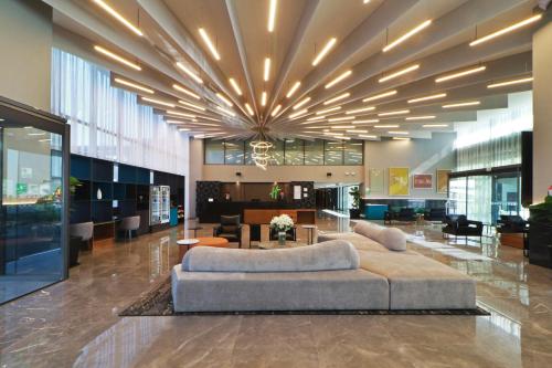 a lobby with a large couch in the middle at Holiday Inn & Suites - Mexico Felipe Angeles Airport, an IHG Hotel in Zumpango de Ocampo