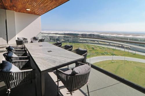 a balcony with a table and chairs and a baseball field at Holiday Inn & Suites - Mexico Felipe Angeles Airport by IHG in Zumpango de Ocampo