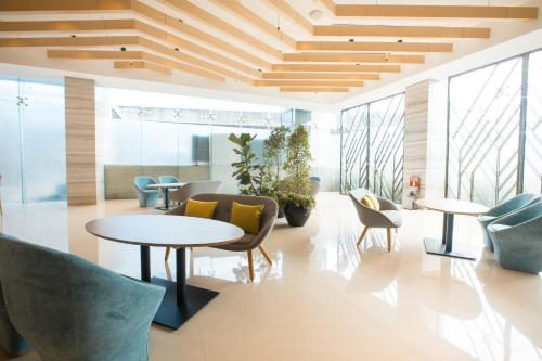 an office lobby with tables and chairs and windows at Holiday Inn Express Manila Newport City by IHG in Manila