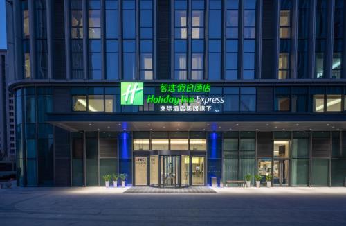 a building with a sign on the front of it at Holiday Inn Express Qingdao Northern West Coast by IHG in Qingdao