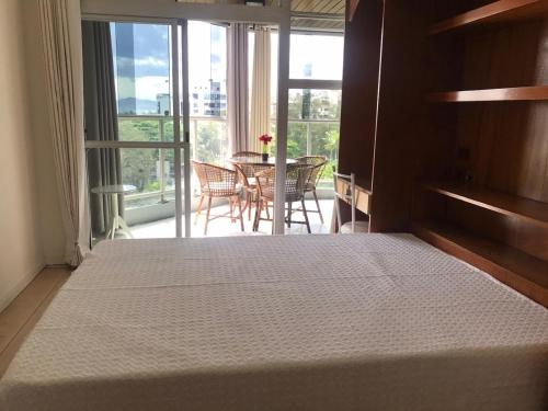 um quarto com uma cama e uma mesa com cadeiras em Vistão do mar - posto 5 Barra da Tijuca no Rio de Janeiro