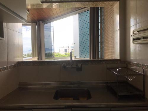 uma casa de banho com um grande lavatório e uma janela em Vistão do mar - posto 5 Barra da Tijuca no Rio de Janeiro