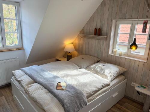 Bett in einem kleinen Zimmer mit zwei Fenstern in der Unterkunft Property in Quedlinburg in Quedlinburg